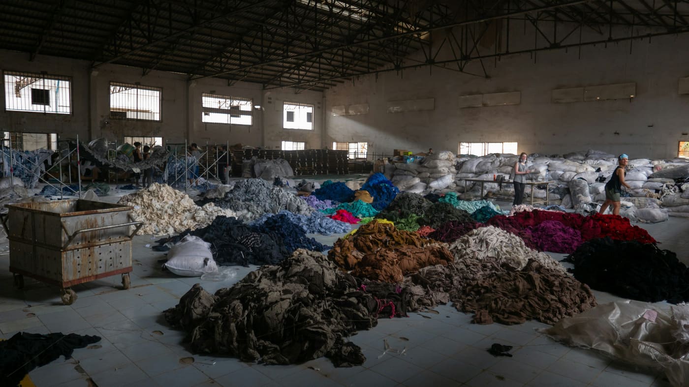 heaps of sorted textile waste in a hall
