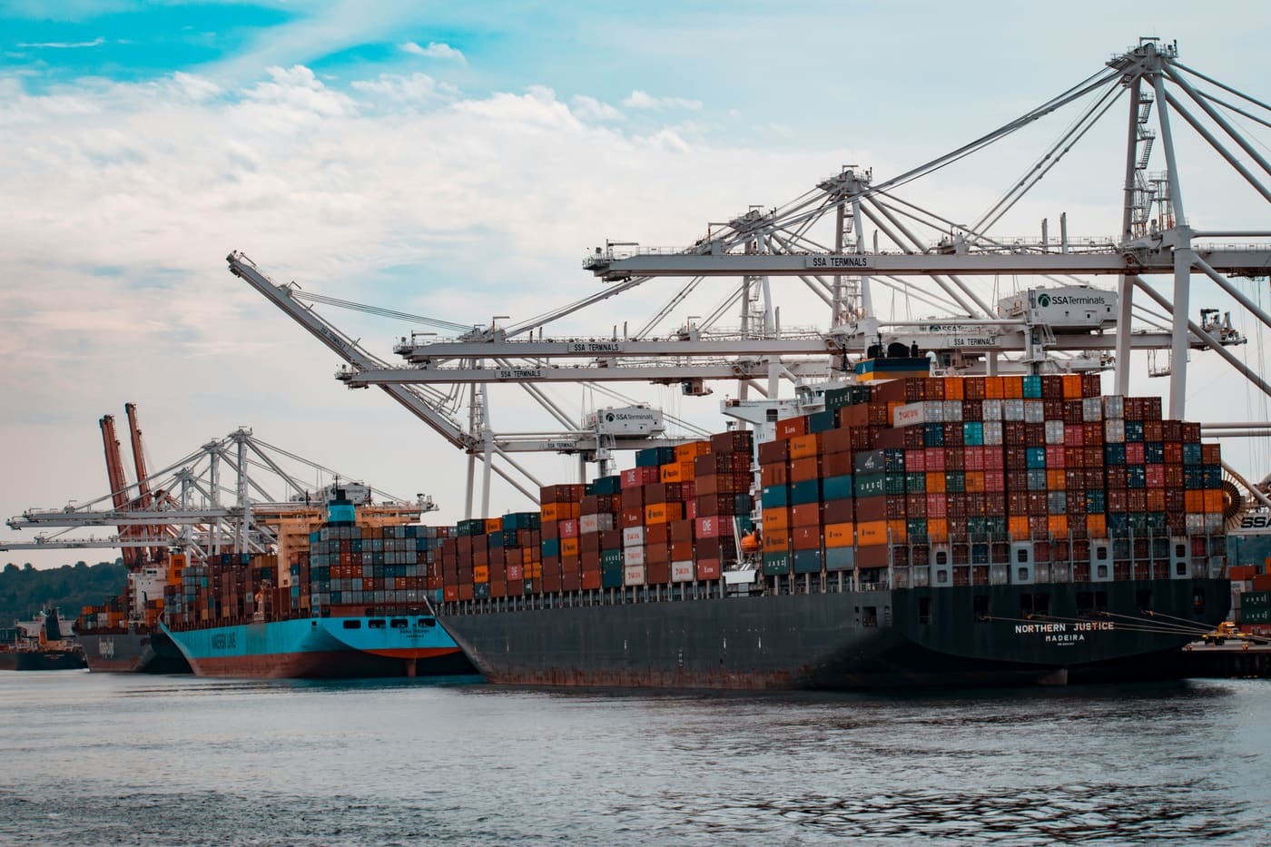 a container ship under cranes at a quay